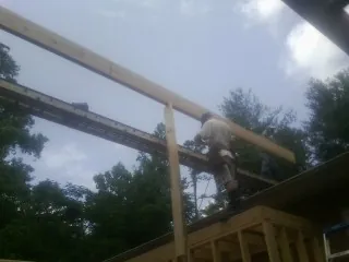 Carpenter setting a ridge beam over a new addition frame — Ice Dam Removal by Roofing Brothers in Clairfield