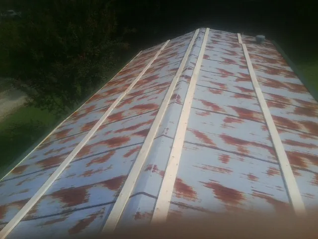 Rusted metal roof panels with new wood purlins before replacement — Storm Damage Roof Repair in Clairfield by Roofing Brothers