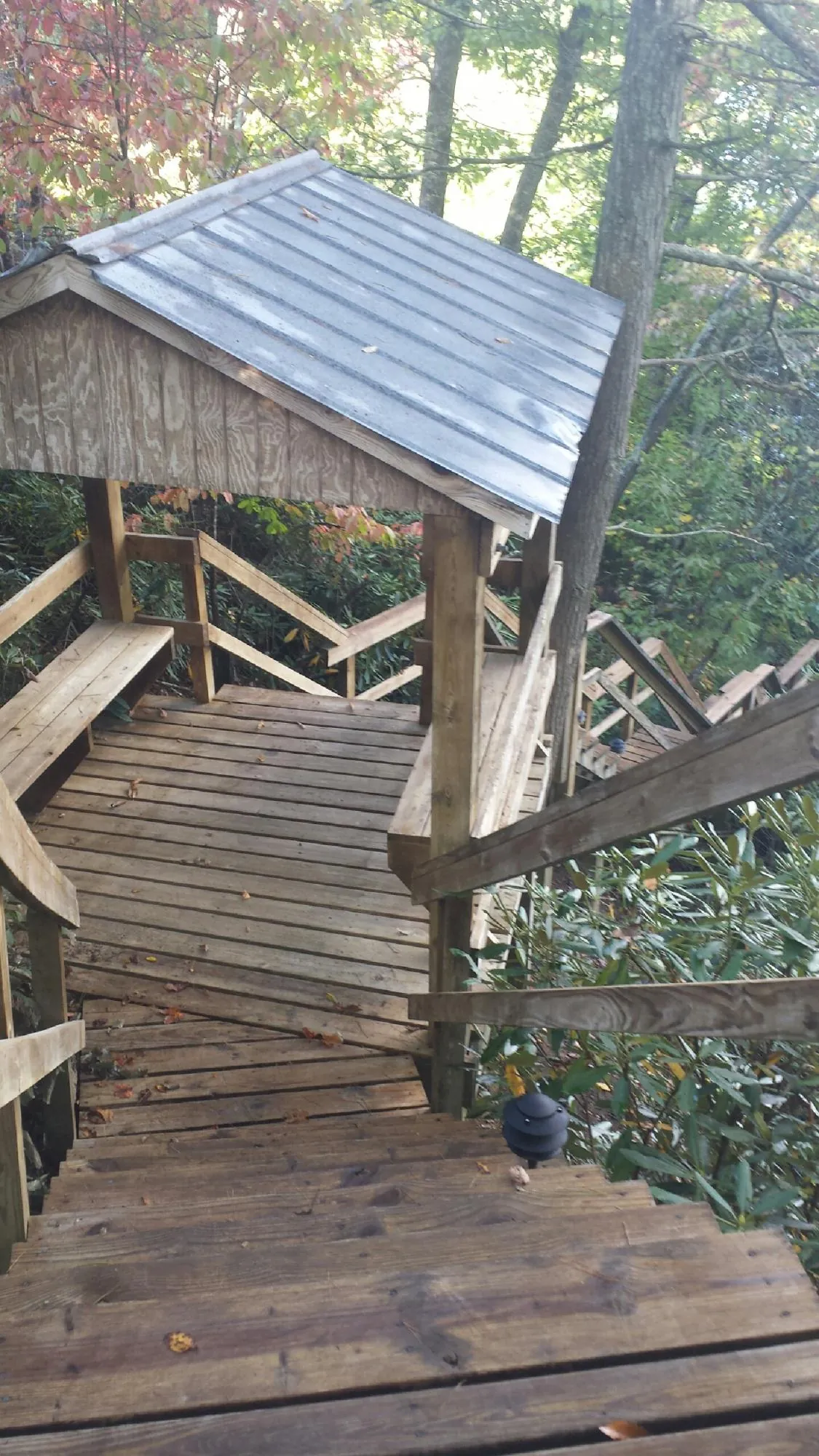 Metal roofed shelter over wooden steps on a wooded walkway — Skylight Repair & Installation work by our crew in Clairfield