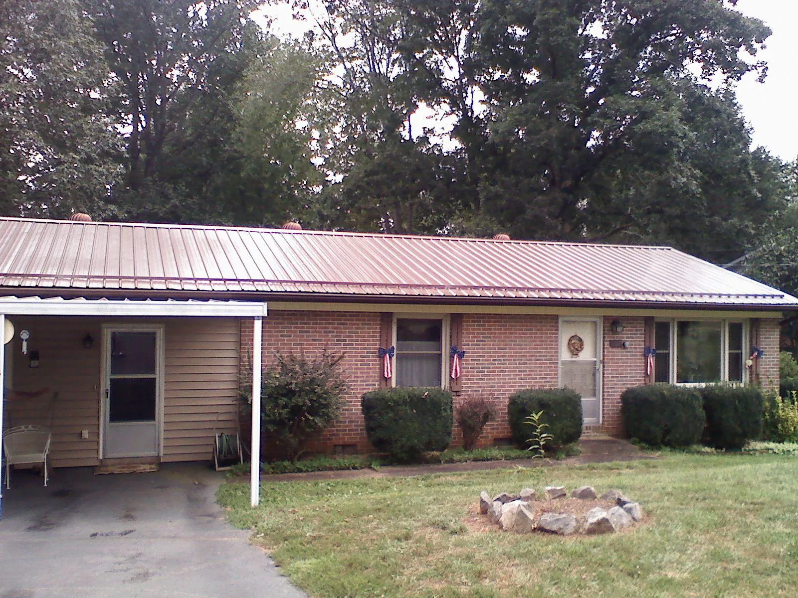 Bronze metal roof and carport on a brick ranch home — Roof Repair work by our crew in Clairfield
